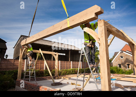 L bâtiment maison, les travailleurs en chêne vert construction bâtiment avec l'aide d'une grue Banque D'Images