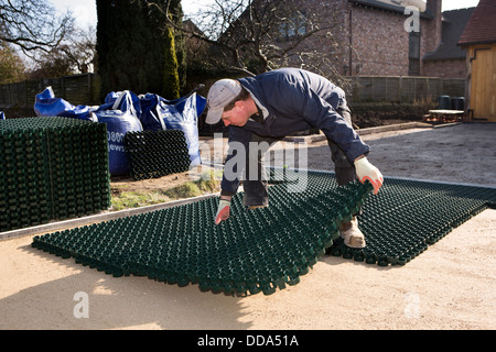 L bâtiment maison, disque de l'aménagement paysager, pose artisan des feuilles en matières plastiques en parking de tapis pour être ensemencée avec de l'herbe Banque D'Images