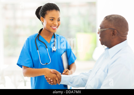 Friendly African American medical infirmière de liaison avec senior patient Banque D'Images