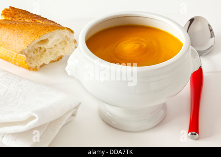 Soupe au potiron - soupe de potiron copieux épais, servi dans un bol tête de lion avec du pain croustillant, dans un cadre lumineux, la lumière. Banque D'Images