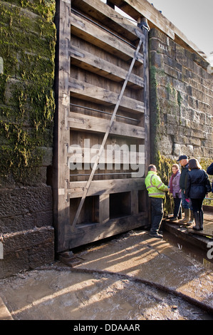 Les gens à l'intérieur d'une écluse drainés à des travaux de rénovation à l'énorme porte en bois - journée portes ouvertes, Bingley's hausse cinq écluses, West Yorkshire, Angleterre, Royaume-Uni. Banque D'Images