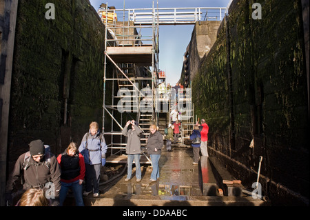 Les gens à l'intérieur d'une écluse, égouttés et tour à la rénovation au travail - journée portes ouvertes, Bingley's hausse cinq écluses, West Yorkshire, Angleterre, Royaume-Uni. Banque D'Images