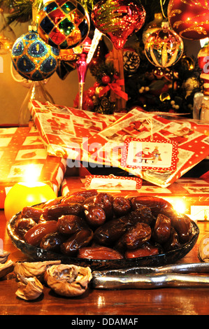 Les dates dans un plat en verre peu profond avec des cadeaux de Noël sous un arbre à l'arrière, Angleterre, Royaume-Uni, Europe de l'Ouest. Banque D'Images