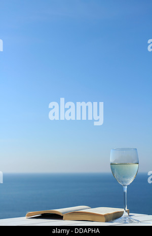 Livre sur table avec verre de vin. Banque D'Images