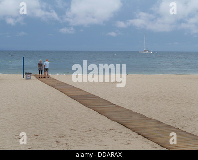 Un couple regarder l'océan dans l'espagnol Mallorca's beach de Magaluf Banque D'Images