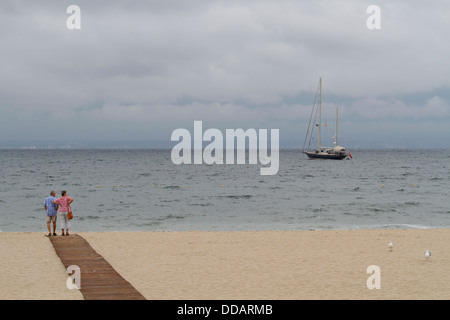 Un couple regarder l'océan dans l'espagnol Mallorca's beach de Magaluf Banque D'Images