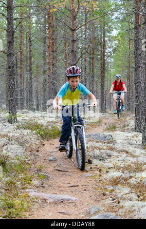 Garçon et la mère à vélo sur le chemin à travers bois, Rörbäcksnäs, dalarna, Suède Banque D'Images