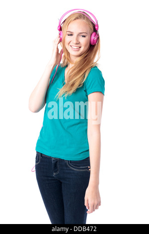 Young woman relaxing with her music debout avec les yeux baissés et un sourire à l'écoute de ses écouteurs, isolated on white Banque D'Images