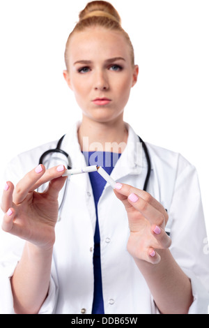 Femme sérieuse briser une cigarette en deux comme un avertissement pour les fumeurs sur les conséquences et les risques pour la santé des fumeurs. Banque D'Images