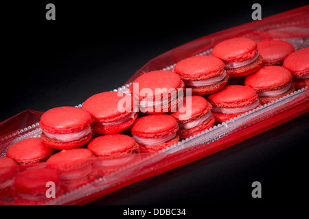 Macarons rouges sur fond sombre Banque D'Images