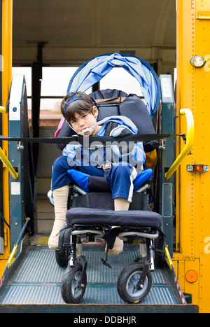 Mobilité petit garçon sur un élévateur de fauteuil roulant d'autobus scolaires Banque D'Images