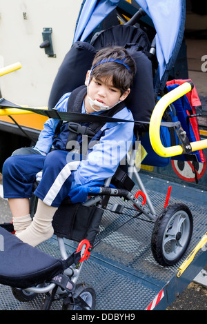 Mobilité petit garçon sur un élévateur de fauteuil roulant d'autobus scolaires Banque D'Images