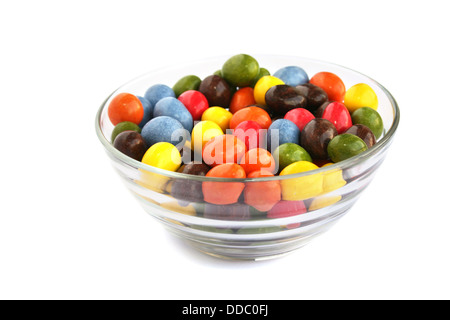 Bonbons colorés avec des raisins secs et les arachides dans vase isolé sur fond blanc. Banque D'Images