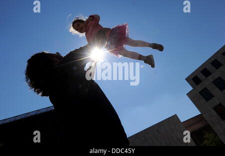 ILLUSTRATION - Une photo montre un homme de jeter sa fille en l'air tandis que le soleil brille dans le ciel à Munich, Allemagne, le 30 août 2013. Photo : Tobias Hase Banque D'Images