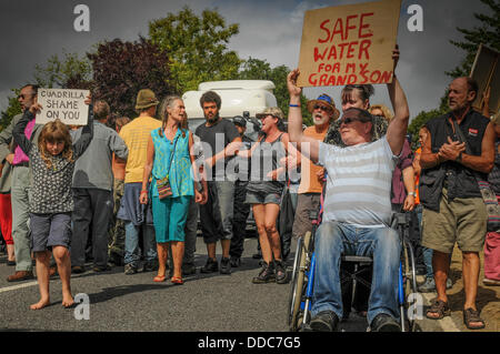 Balcombe, West Sussex, UK. Août 30, 2013. Les environnementalistes de fracturation à pied à l'avant qu'un autre camion est escorté à Cuadrilla site par la police. Robin Bothwell, en fauteuil roulant, d'Eastbourne sur la droite fait son point de vue et de la jeune fille fait le sien. Les militants anti fracturation protestent contre les forages d'essai par Cuadrilla sur le site de West Sussex qui pourraient mener à la processus de fracturation controversée. Camp de la route continue de croître. Crédit : David Burr/Alamy Live News Banque D'Images