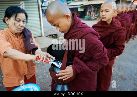 Myanmar (Birmanie), l'État Môn, Mawlamyine (Moulmein), des moines bouddhistes procession recevoir des offrandes Banque D'Images