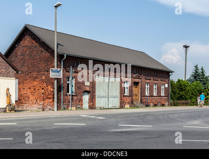 Maison en brique rouge avec portes en bois et d'une cigogne nid sur un poteau dans le village sorabe de Nissen, Spreewald, Allemagne Banque D'Images