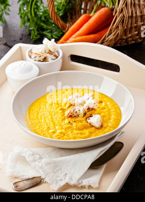 Soupe de carottes avec des croûtons sur fond de bois Banque D'Images