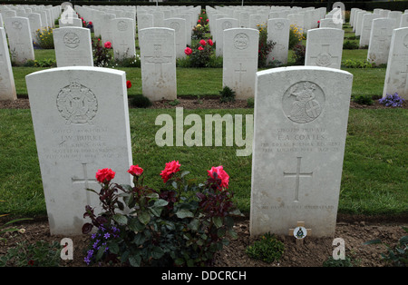 Pierres tombales au cimetière Biritish Bayeux, France. Roses avaient tendance entre les tombes. Banque D'Images