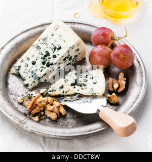Fromage bleu avec du miel, les noix et les raisins sur la plaque Banque D'Images