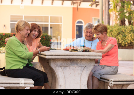 Senior friends la lecture de messages texte Banque D'Images