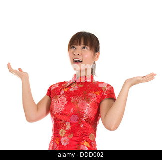 Jolie femme asiatique avec une robe traditionnelle chinoise ou cheongsam qipao bras ouverts jusqu'à la surprise. Le nouvel an chinois Concept, modèle féminin isolé sur fond blanc. Banque D'Images