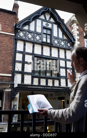 Un guide d'excursion, Roger Stephens, soulignant l'architecture médiévale de la ville de Chester, Cheshire, Angleterre, Royaume-Uni. Banque D'Images