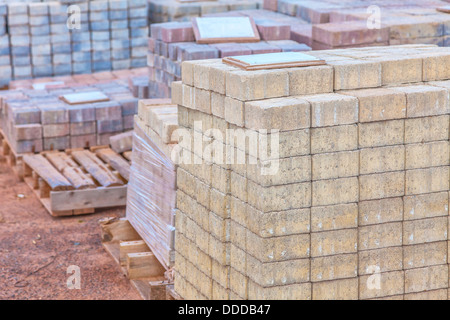 Des piles de pavés de béton de couleur différents (pavé) ou blocs de patio organisées sur des palettes en bois et à la vente. Banque D'Images