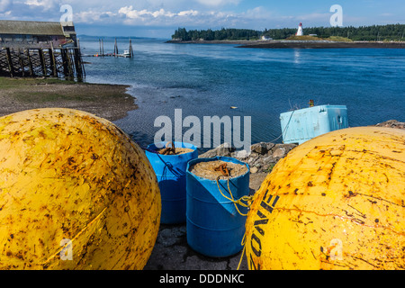 Une vue de Lubec, Maine mer avec une grande flotte de métal jaune au premier plan Mulholland Point Lighthouse en arrière-plan. Banque D'Images