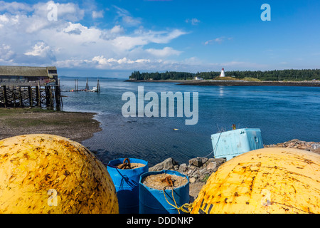 Une vue de Lubec, Maine mer avec une grande flotte de métal jaune au premier plan Mulholland Point Lighthouse en arrière-plan. Banque D'Images