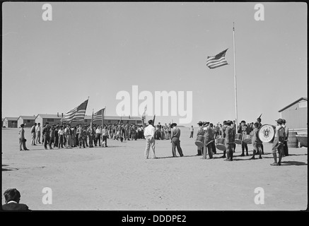 Une photographie du Granada Relocation Center à Amache, Colorado, représentant une scène du défilé du jour commémoratif des scouts. L'image montre les évacués et les individus du centre prenant part à la parade lors d'un événement historique important. Banque D'Images