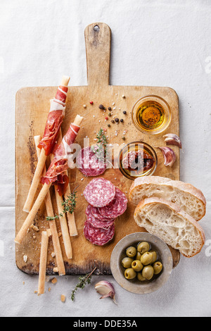 Bâtonnets de pain avec du jambon et du salami sur fond de bois Banque D'Images