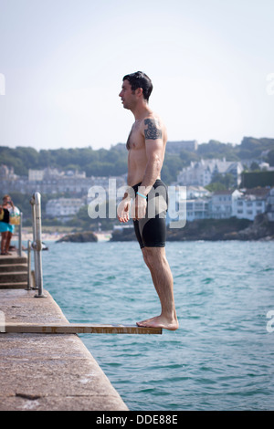 Un homme d'une plongée plongée fait maison dans le quai à St Ives, Cornwall Banque D'Images