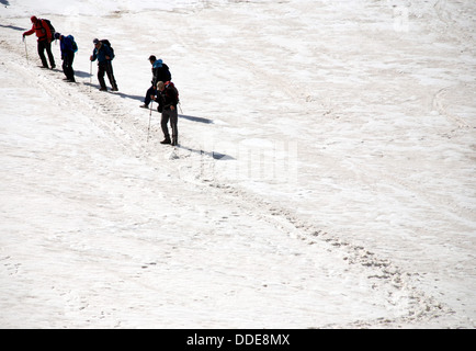 Les randonneurs traverser une pente de neige raide haut dans les montagnes du Tadjikistan de Fann Banque D'Images