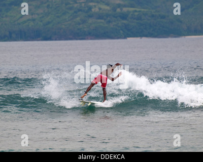 L'Indonésie n boy surf les vagues entre Lombok et Gili Trawangan Banque D'Images