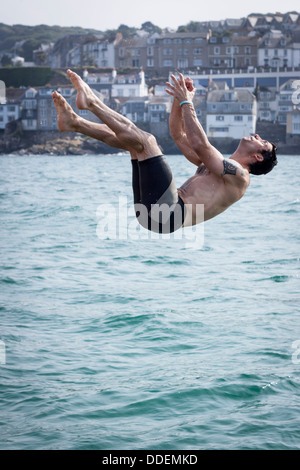 Un homme d'une plongée plongée fait maison dans le quai à St Ives, Cornwall Banque D'Images