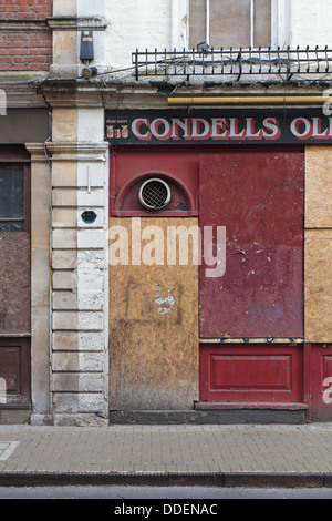 Une vieille Pub Boarded-Up dans le centre de Bristol avec langage et Red-Painted l'aggloméré sur Windows. Banque D'Images