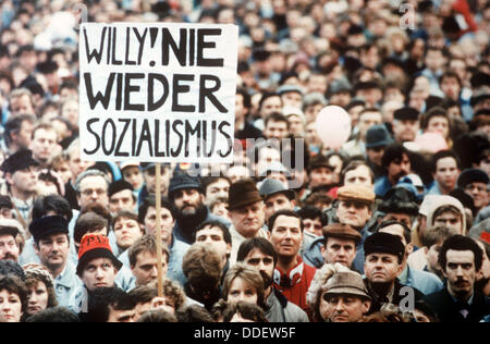 Tenir les spectateurs une bannière à lire 'Willy ! Pas plus le Socialisme !" en tant que sociaux-démocrates allemands (SPD) président honoraire Willy Brandt prononce un discours lors de la campagne électorale du SPD de RDA à Erfurt, Allemagne, 03 mars 1990. Le 18 mars 1990, le GDR a tenu les premières élections libres après la chute du mur en novembre 1989 et l'annulation de la décision de la RDA du SED parti unique revendication pour le leadership de la loi fondamentale le 01 décembre 1990. Banque D'Images