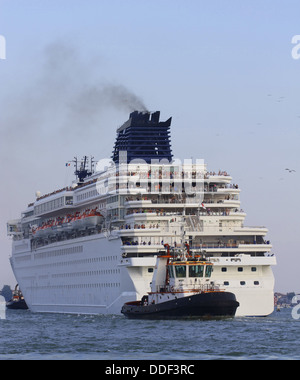 Remorqueur puissant alors que la manœuvre avec précision grand navire de croisière de la ville portuaire Banque D'Images