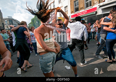 Les couples danser pour système de son dans la rue latérale à Notting Hill Carnival Banque D'Images