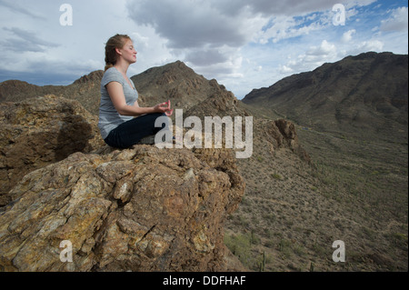 Woman meditating in desert, Tucson AZ Banque D'Images