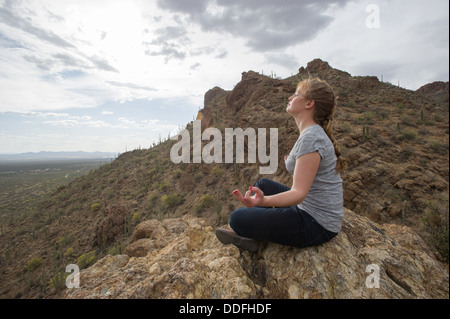 Woman meditating in desert, Tucson AZ Banque D'Images