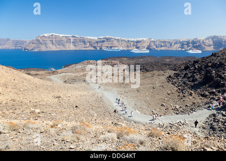 Les touristes à la découverte de l'île de Nea Kameni à Santorin, Grèce. Banque D'Images