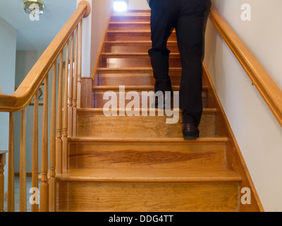 Homme marchant vers le haut des escaliers Résidentiels Banque D'Images