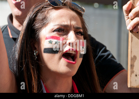 Jeune femme syrienne avec drapeau peint sur sa joue à la manifestation contre l'intervention en Syrie Banque D'Images