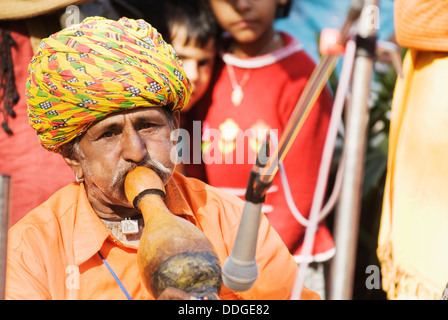 L'homme en robe traditionnelle du Rajasthan jouant pungi à Surajkund Mela, Faridabad, Haryana, Inde Banque D'Images