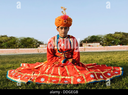 Portrait d'un homme en robe traditionnelle du Rajasthan sitting on grass, Jaipur, Rajasthan, Inde Banque D'Images