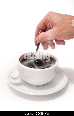 Une main en remuant une tasse de café noir blanc sur un fond blanc isolé. Banque D'Images
