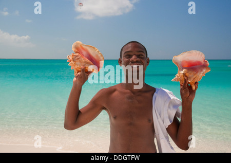 Friendly man vente de coquillages sur la plage de Grace Bay, à Providenciales, Turks et Caïques Banque D'Images