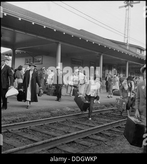 À Woodland, en Californie, des familles d'ascendance japonaise sont vues quitter le quai de la gare pour monter à bord d'un train, reflétant les efforts de relocalisation en temps de guerre pendant la seconde Guerre mondiale. Banque D'Images